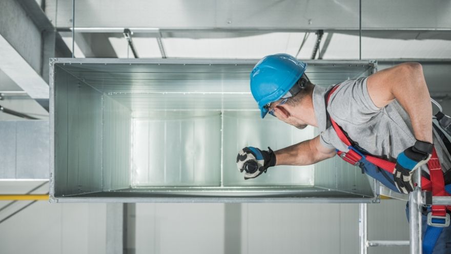 Instalator montuje system wentylacyjny do nawiewników liniowych