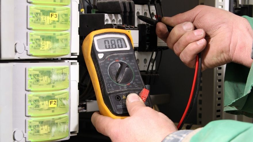 Elektroinstalator sprawdza pomiar rezystancji uziemienia miernikiem