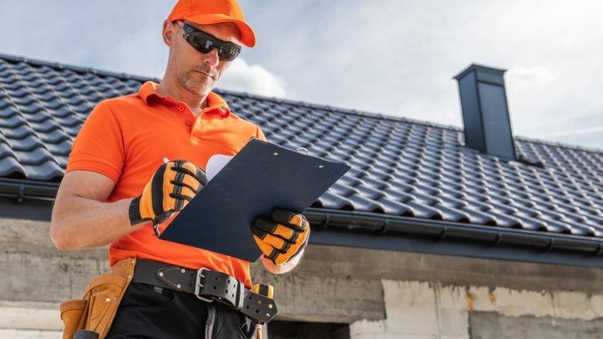 Instalator sprawdza postęp prac elektrotechnicznych w dokumentach na placu budowy