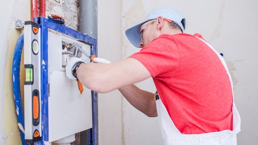 Instalator montuje stelaż podtynkowy do łazienki