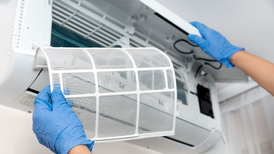 Instalator wymienia filtr w klimatyzatorze naściennym w jednostce wewnętrznej