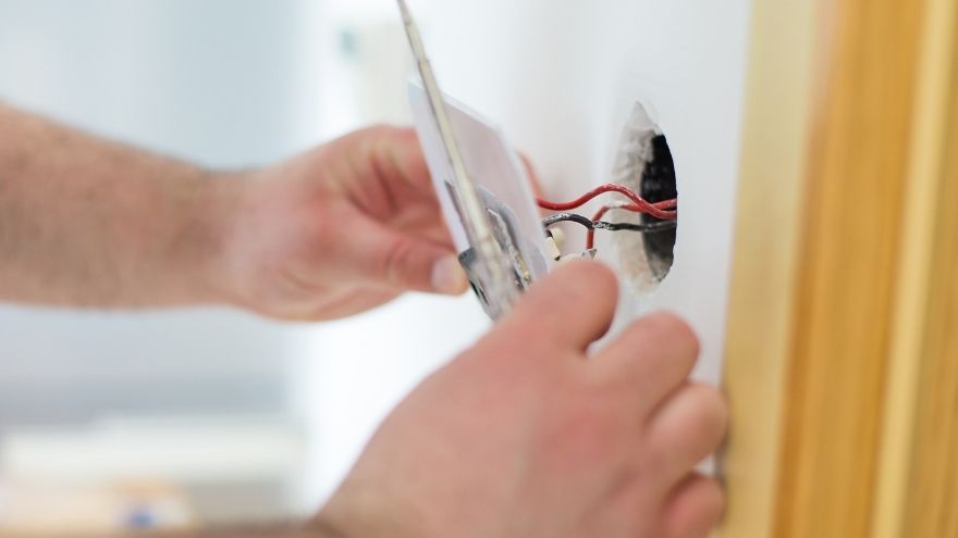 Instalator podłącza włącznik światła krzyżowy w salonie