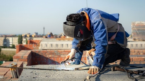 Instalator montuje kable grzejne na dachu płaskim
