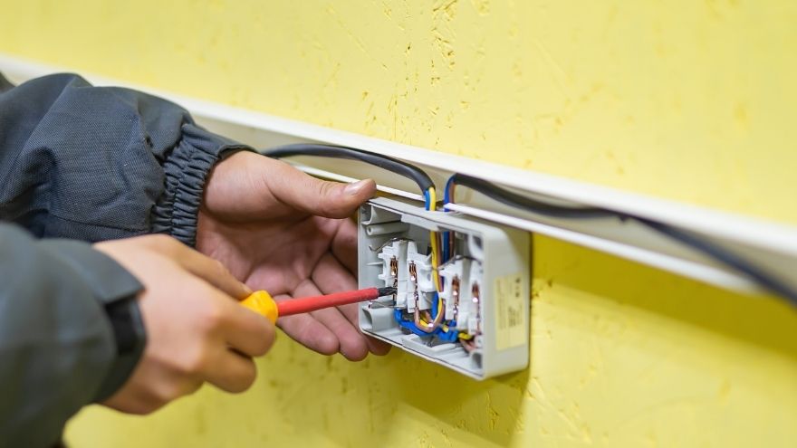 instalator elektryk zeruje gniazdko elektryczne w obwodzie