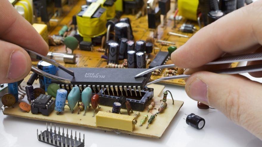 Informatyk montuje części elektrotechniczne w układzie scalonym