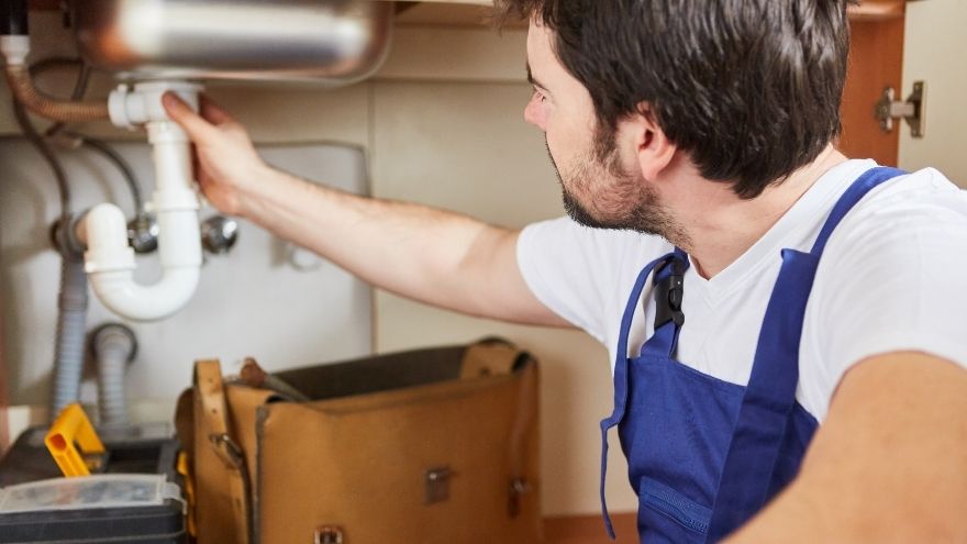Instalator hydrauliczny udrażnia rury kanalizacyjne metodą WUKO w kuchni