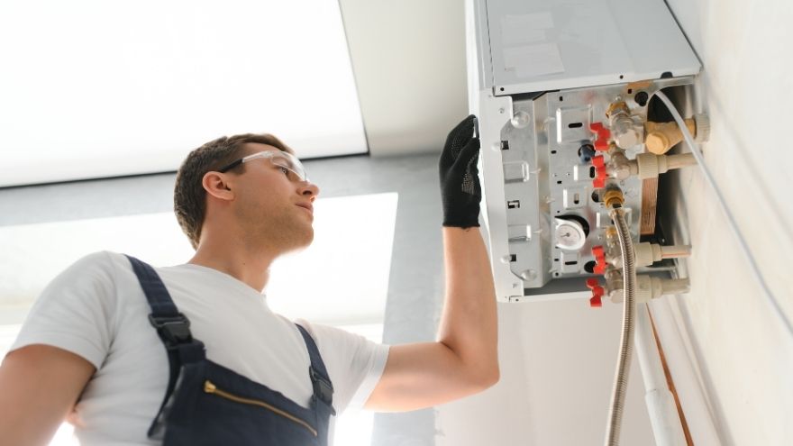 Instalator sprawdza działanie kotła gazowego wiszącego w kuchni