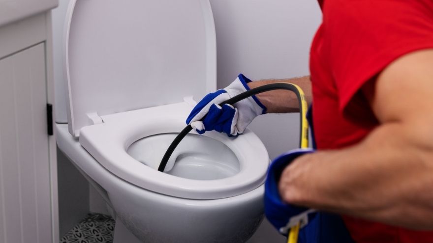 Instalator hydraulik oczyszcza instalację sanitarną w łazience