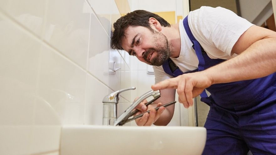 Instalator sprawdza baterię umywalkową w łazience przed bulgotaniem