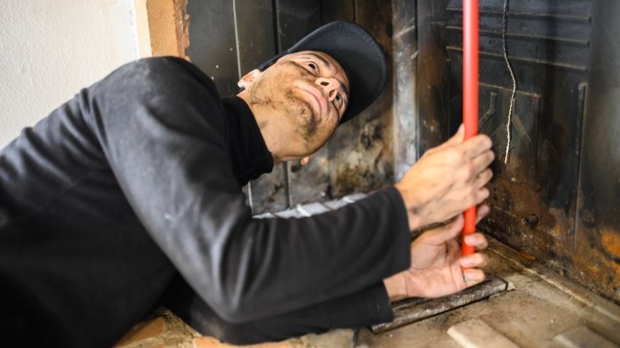 Instalator sprawdza system kominowy w mieszkaniu jednorodzinnym