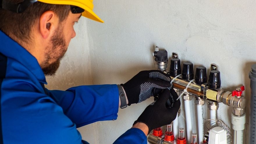 Instalator montuje rotametry do ogrzewania płaszczyznowego na ścianę