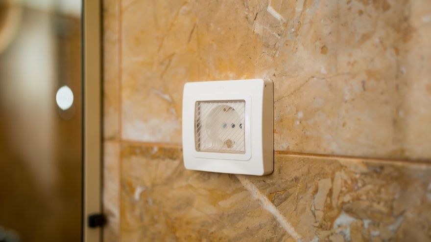 Електрична розетка з кришкою на стіні у ванній кімнаті Gniazdko elektryczne z osłoną na ścianie w łazience