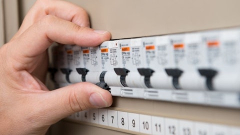 Elektryk sprawdza działanie rozdzielnicy oświetleniowej włączając bezpiecznik