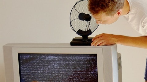 Domownik ustawia antenę wewnętrzną na telewizorze w salonie