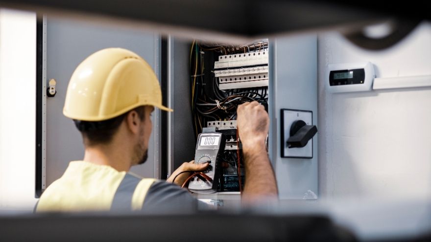 Elektryk sprawdza stan i napięcie instalacji elektrycznej przy rozdzielnicy