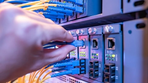 Technik informatyk wkłada wtyki kabli światłowodowych do gniazd routera