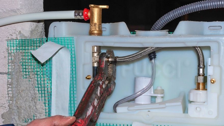 Instalator montuje spłuczkę podtynkową w łazience