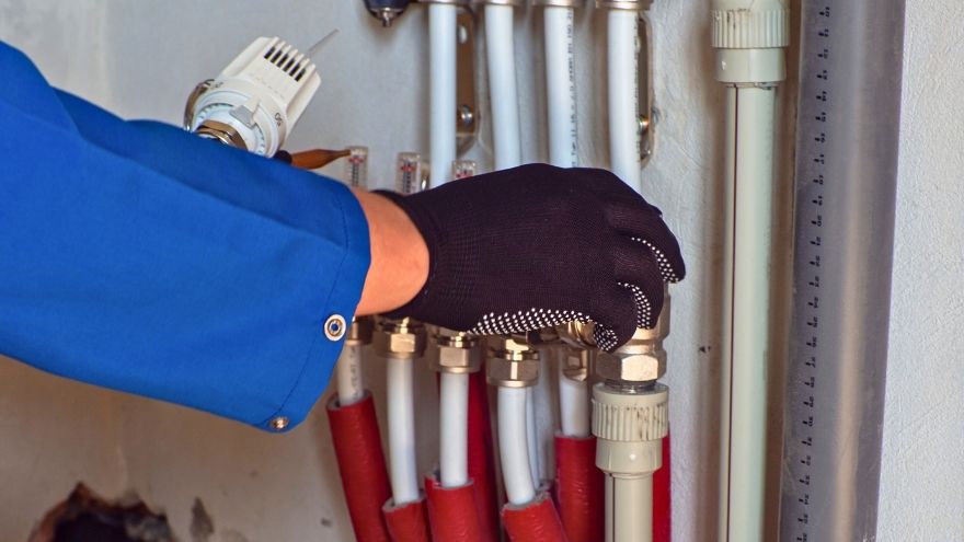 Instalator podłącza system grzewczy w nowoczesnym budownictwie