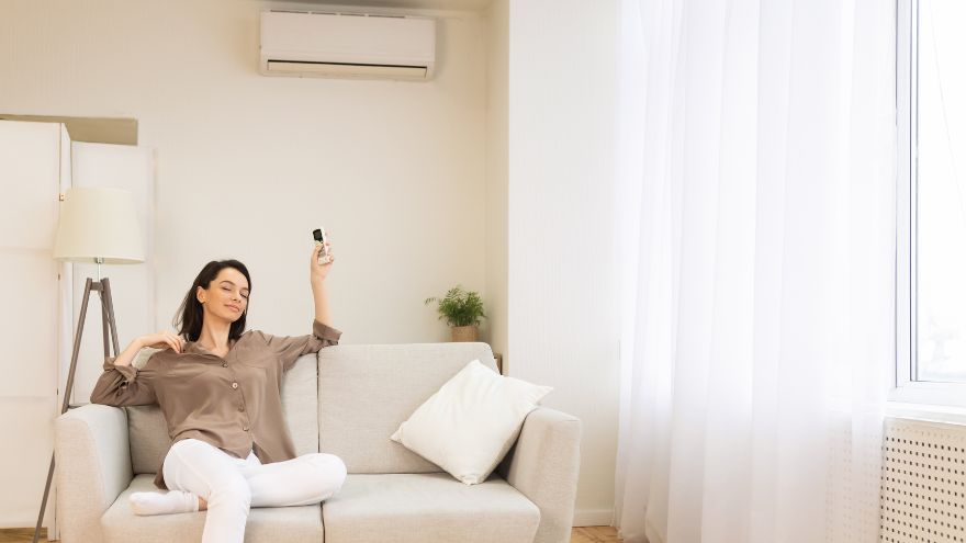 Kobieta na kanapie w salonie domu jednorodzinnego z klimatyzacją