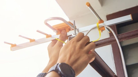 Technik elektryk ustawia antenę zewnętrzną na sygnał telewizyjny