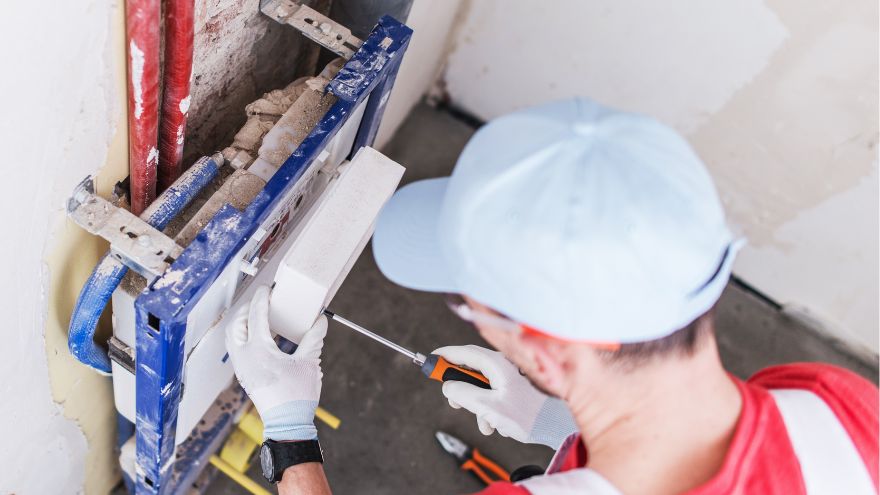 Instalator montuje spłuczkę podtynkową ze stelażem podtynkowym w łazience