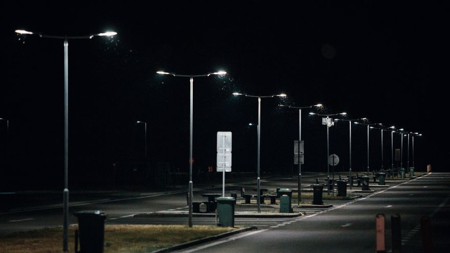 Parking nocą z latarniami ulicznymi na stalowych słupach