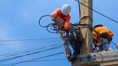 Elektrycy wysokich napięć na słupie elektrycznym
