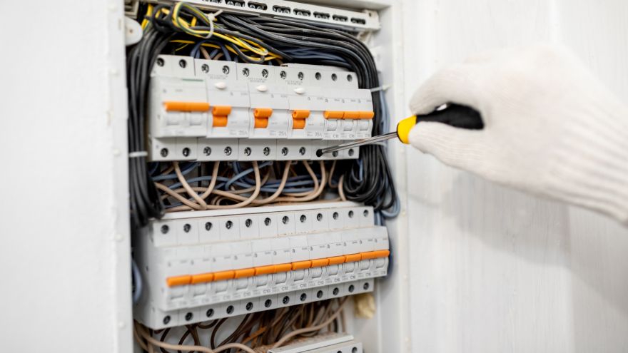 Instalator naprawiający rozdzielnicę elektryczną