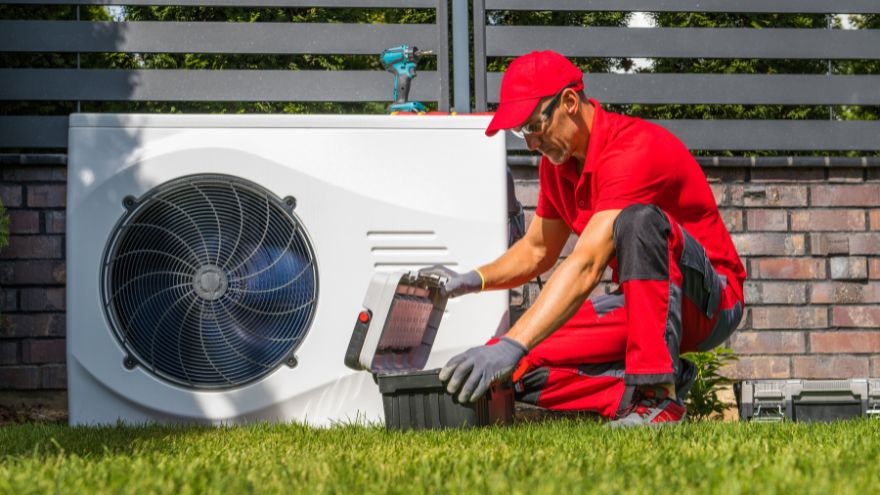 Instalator wyjmujący narzędzia obok pompy ciepła