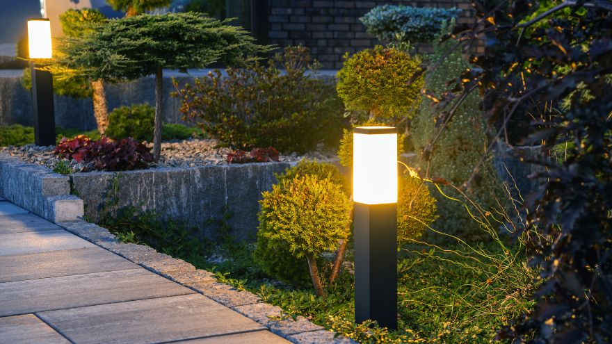 Nowoczesne lampy ogrodowe umieszczone przy kostce