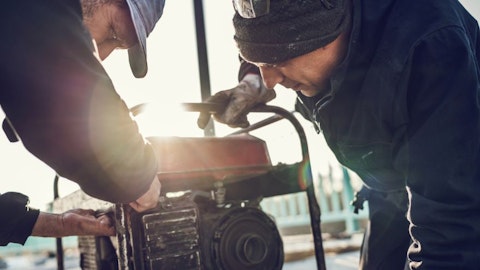 Dwóch mężczyzn naprawia i podłącza generator prądu