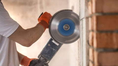 Instalator trzymający bruzdownicę do betonu
