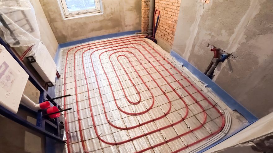 Червоні труби, укладені на ізоляції в сирій ванній кімнаті