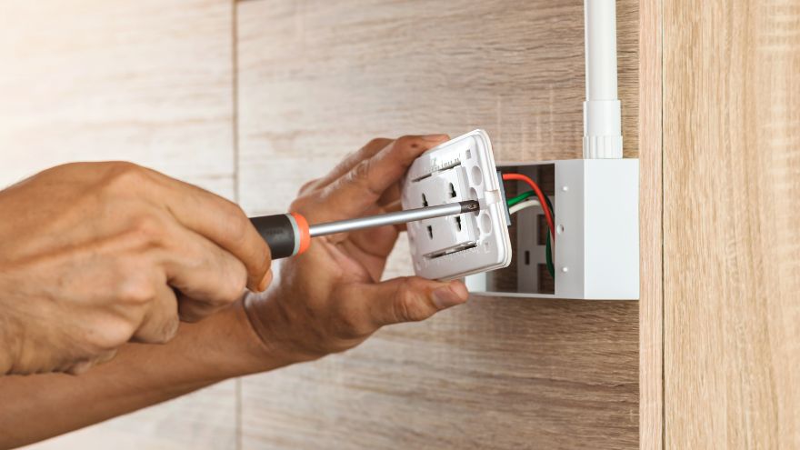 Інсталятор, що прикручує електричну розетку