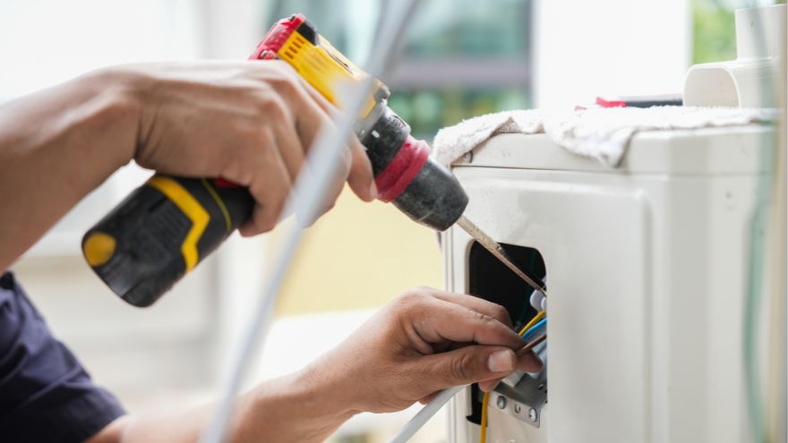 Фахівець, що використовує дриль для підключення електричної установки