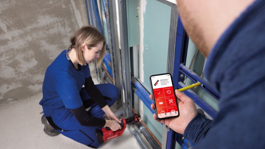Mężczyzna trzymający telefon w ręcę z produktem rothenberger