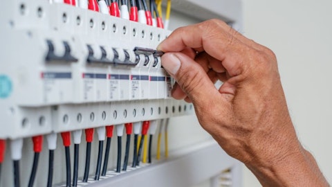 Ręka elektryka montująca wyłącznik modułowy w rozdzielnicy