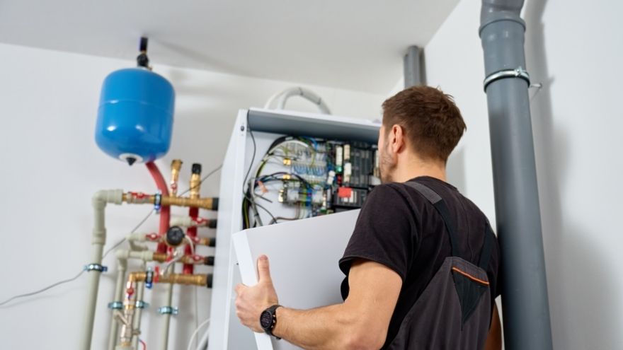 Serwisant sprawdzający sterownik i instalację elektryczną pompy ciepła