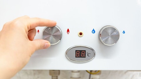 Dłoń regulująca temperaturę na panelu sterowania kotła gazowego
