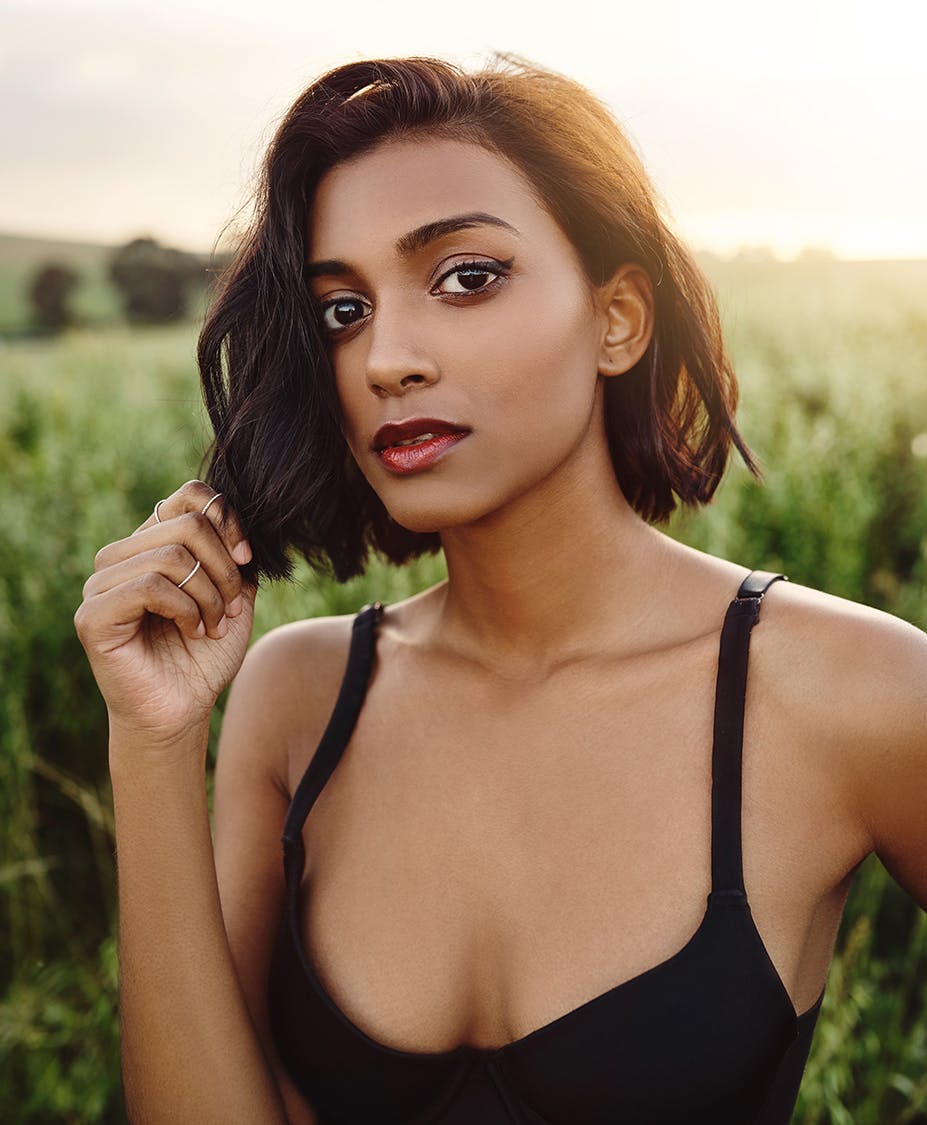 Woman wearing a tank top and standing in a field