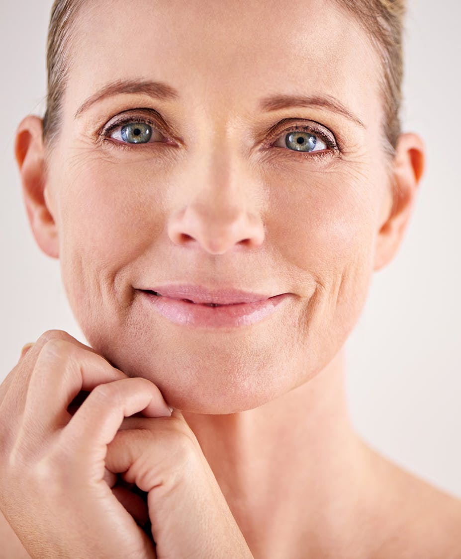Up close picture of a woman holding her hands together under her chin