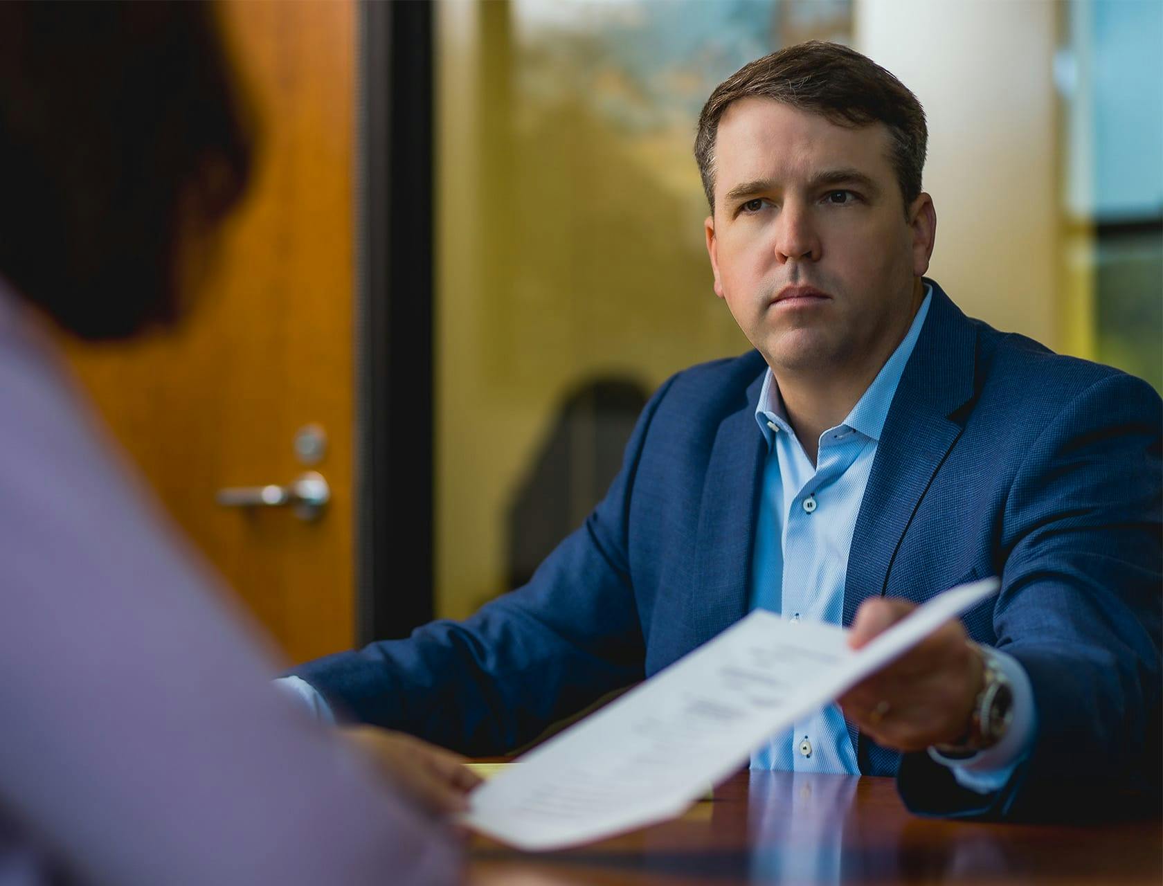 attorney handing a form to the client to fill out