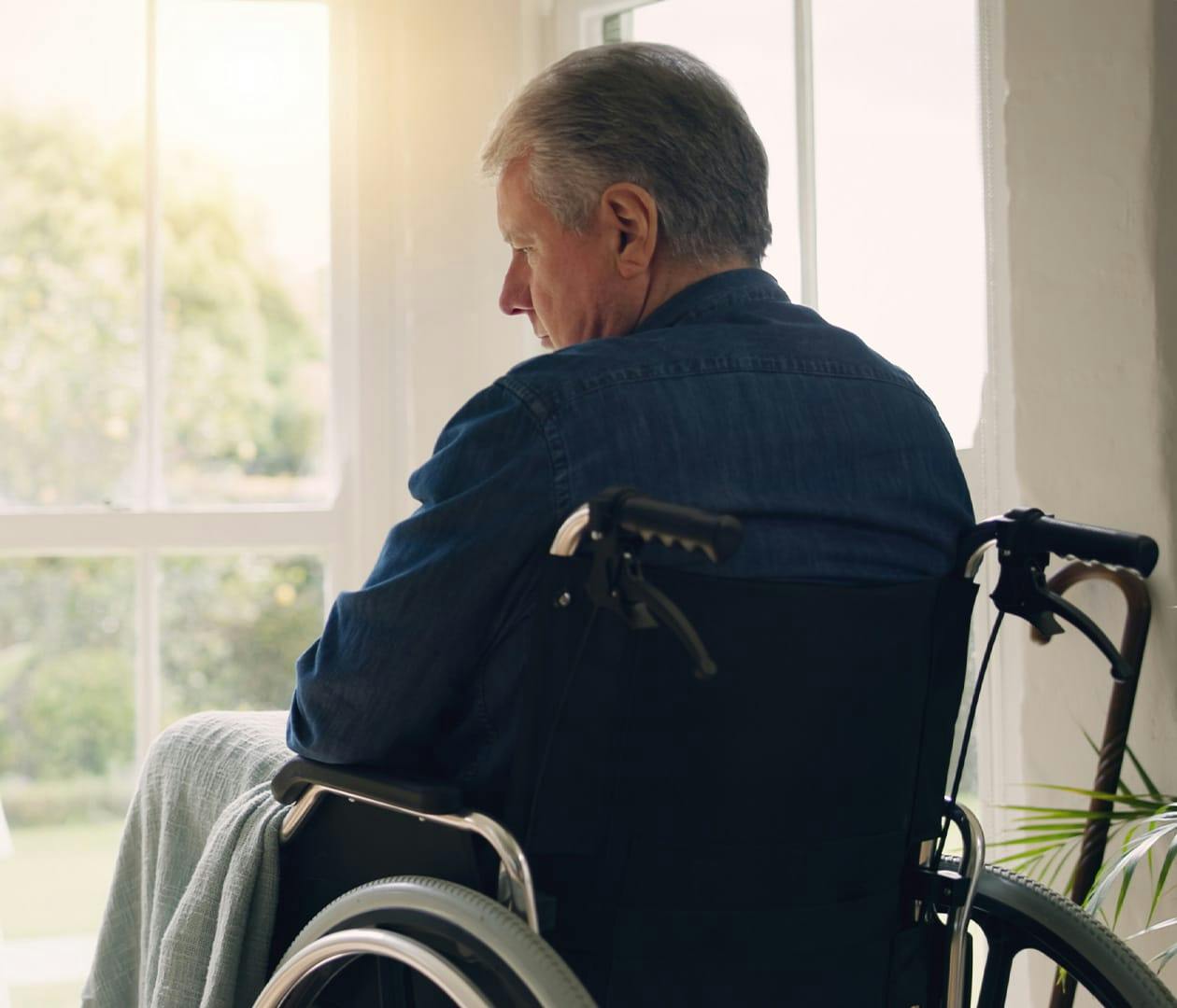 man in wheelchair facing the window