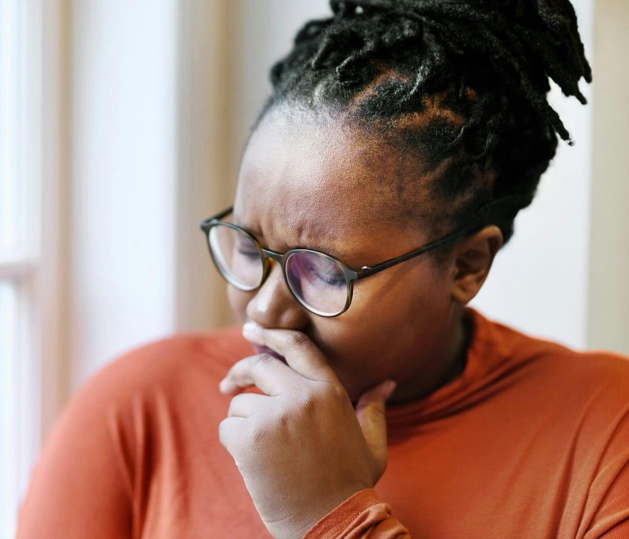 woman looking down and sad with hand on her face