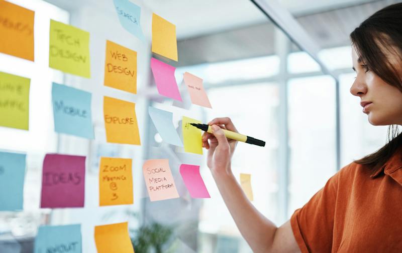 A woman writing on some sticky notes