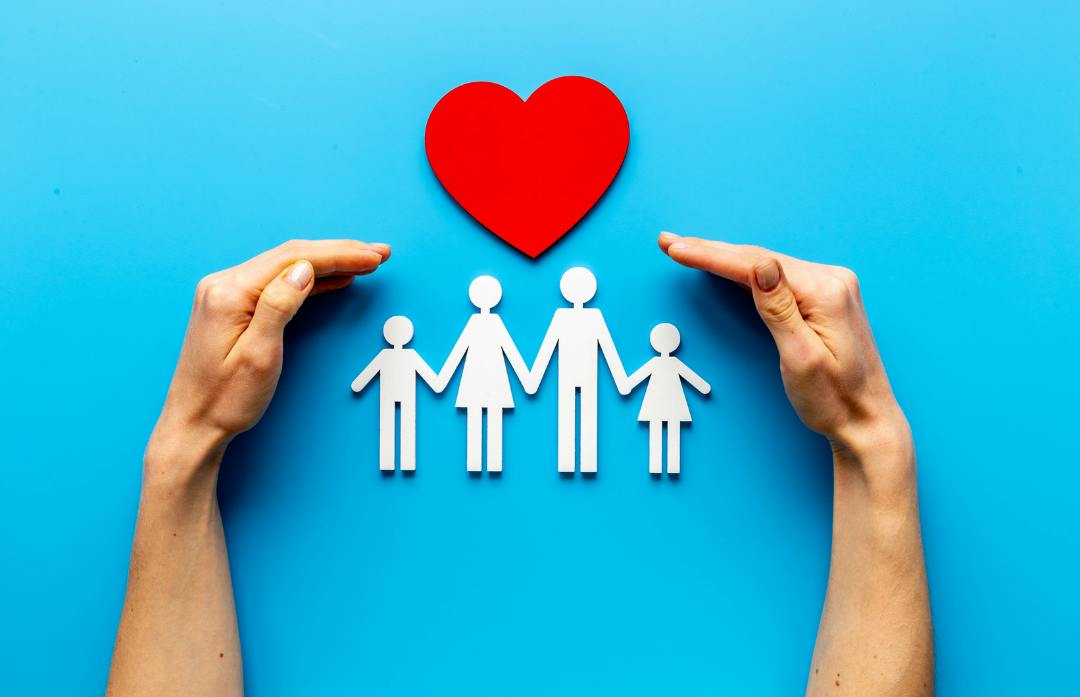 A paper cut-out of a family and a heart