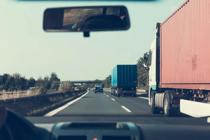 A person driving alongside trucks