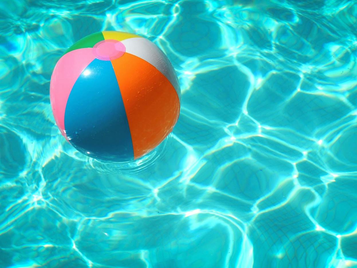 A rainbow ball floating in a pool