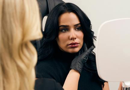 woman looking at a handheld mirror