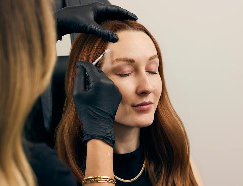 woman getting an injection in her forehead